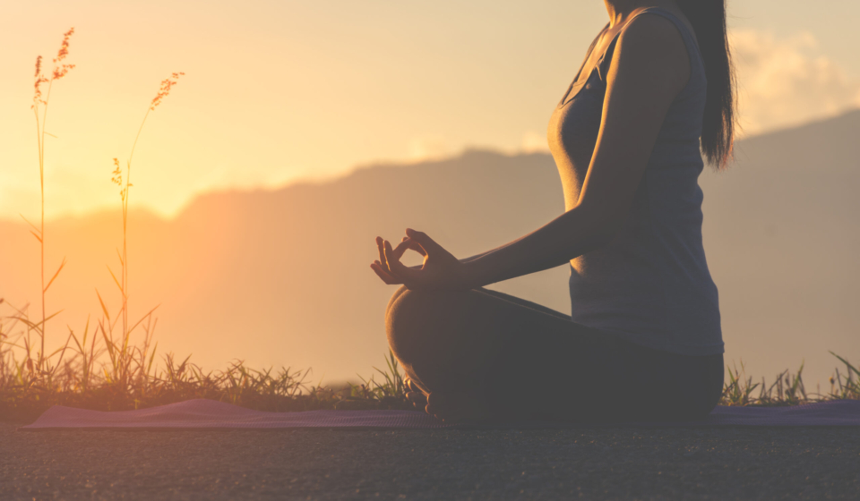 silhouette fitness girl practicing yoga on mountain with sun light